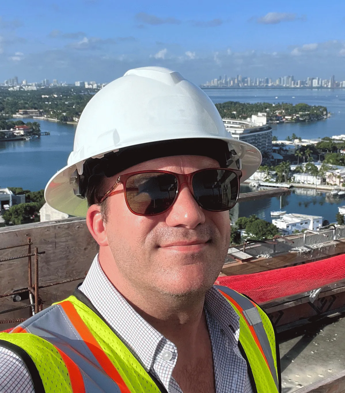 James J. Cloud on a Miami high-rise job site, with Biscayne Bay and the skyline behind