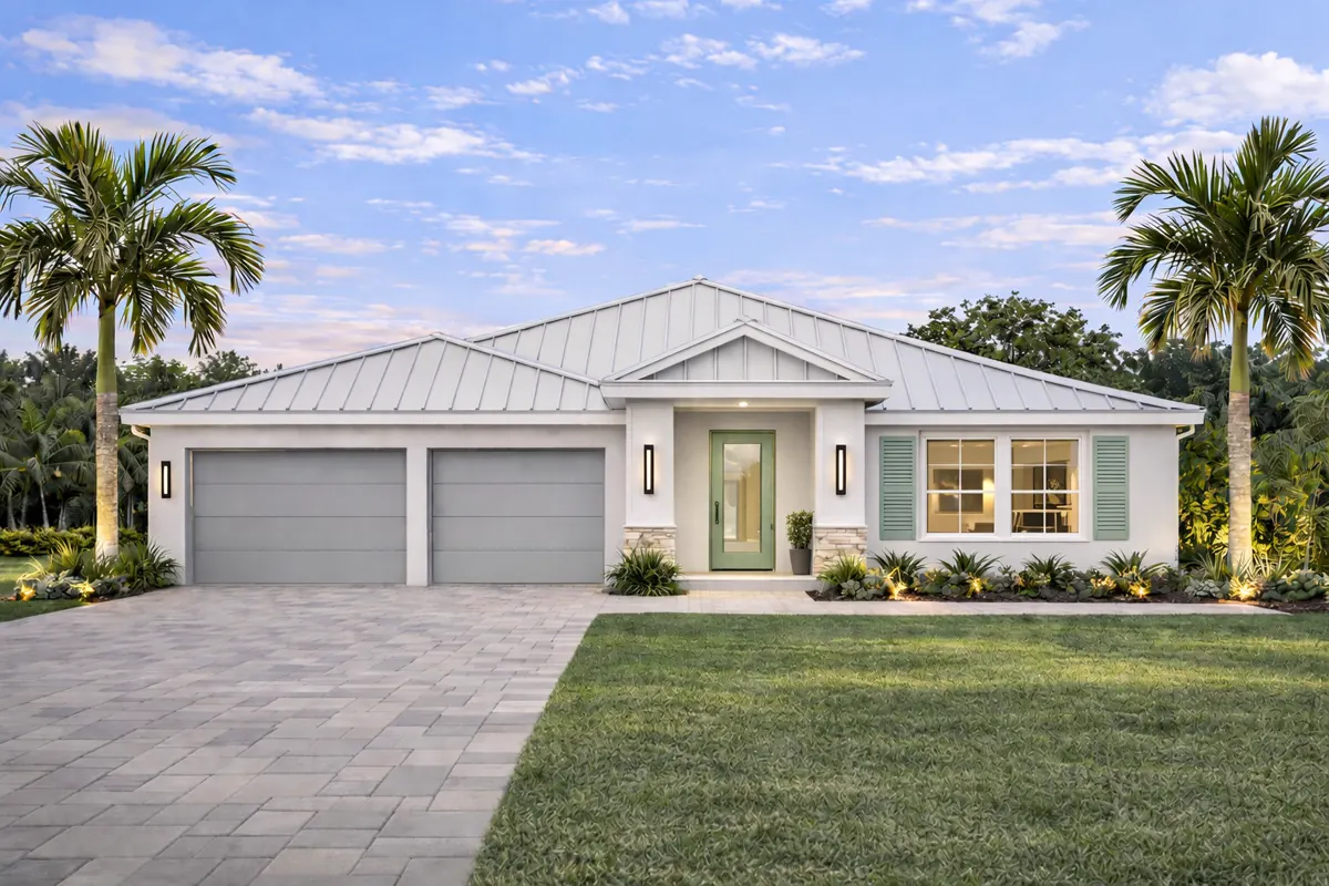 Aria Collection custom home at dusk with a white metal roof and gabled entry