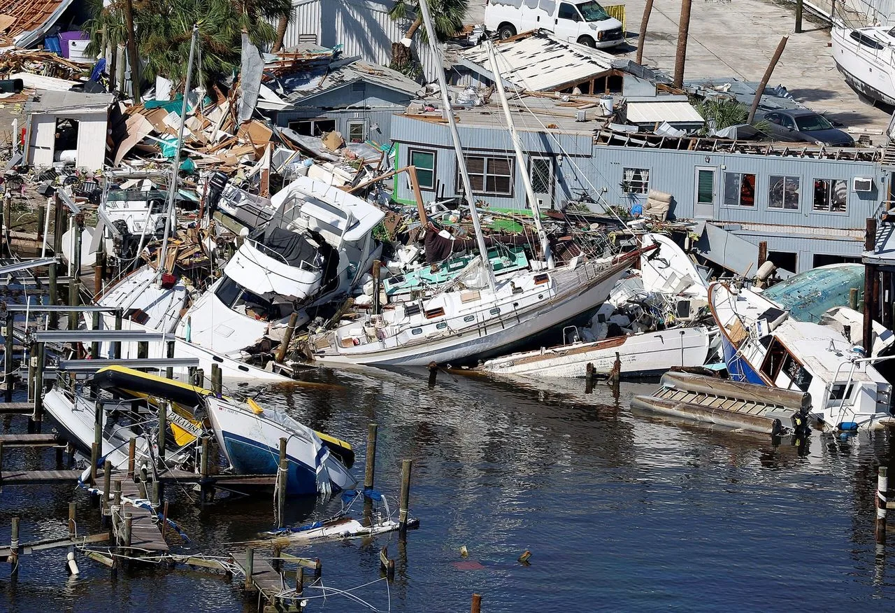 Boats piled up and sunk in a marina after a hurricane