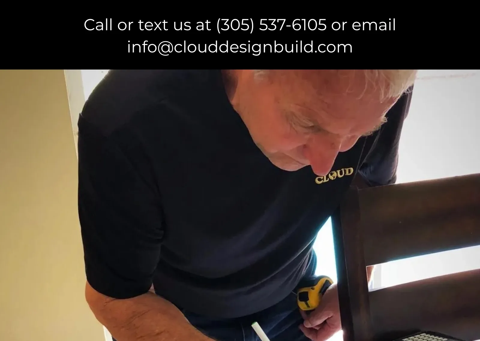 Cloud Design Build team member measuring a wood chair frame with a tape measure