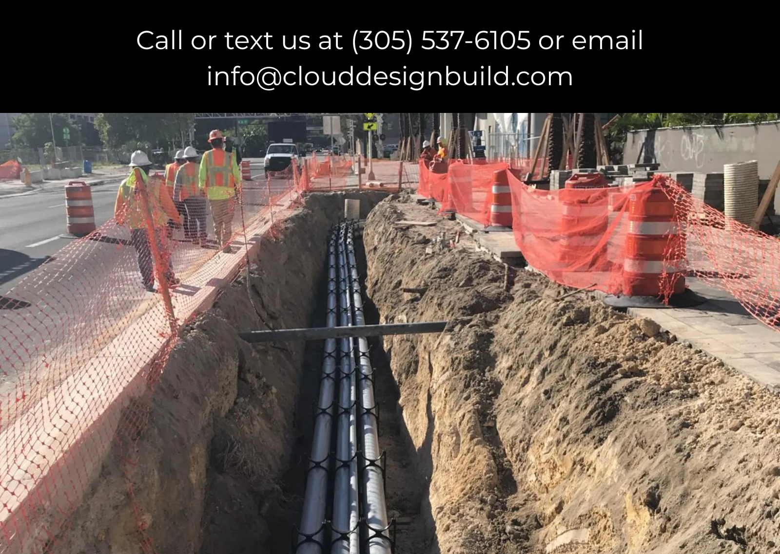 Crew inspecting a utility pipe trench along a city street